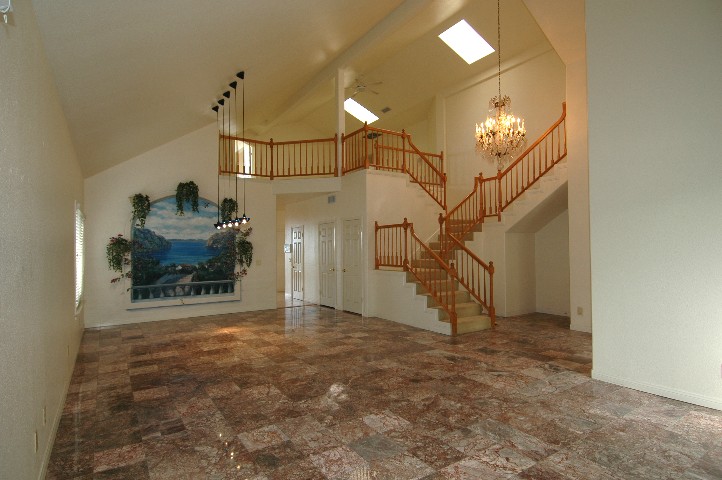Custom Lighting... Rich Oak Staircase... and Mediterranean Mural accent the formal space