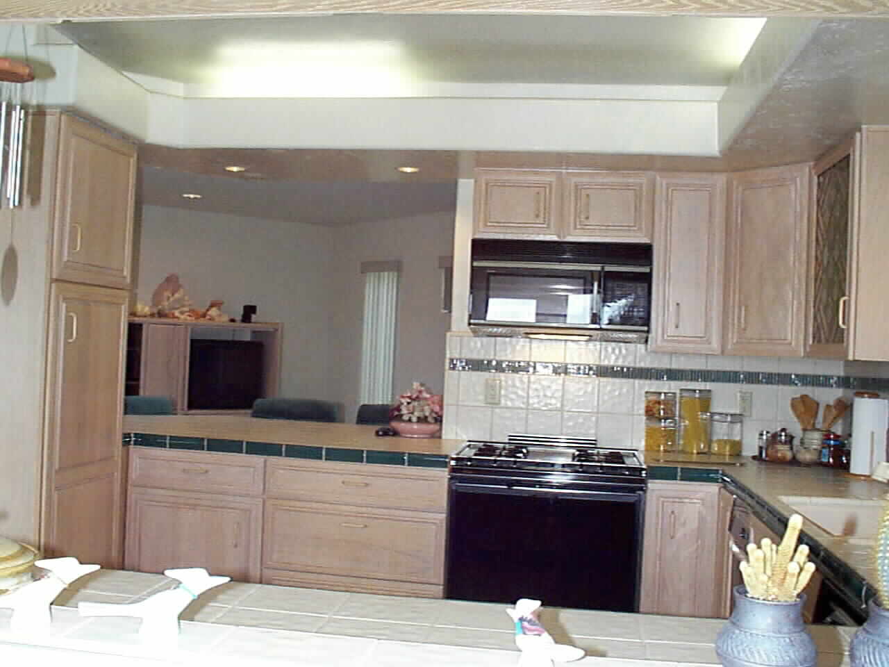 Looking through the glass doored pass through from the Dining Room  through the Kitchen and over the Breakfast Bar to the Family Room