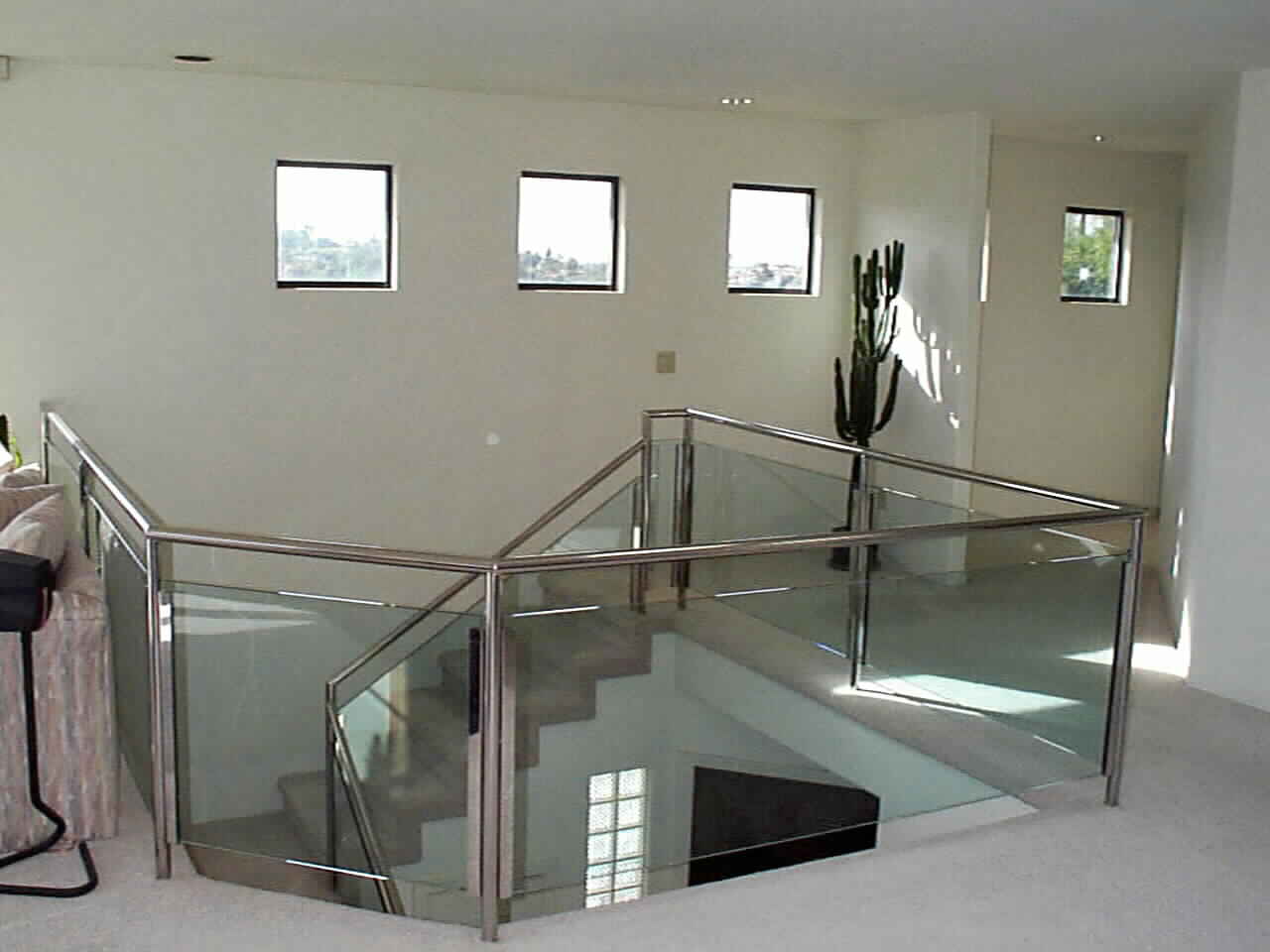 Polished Stainless Steel and Glass Staicase rising from Black Marbled Entry